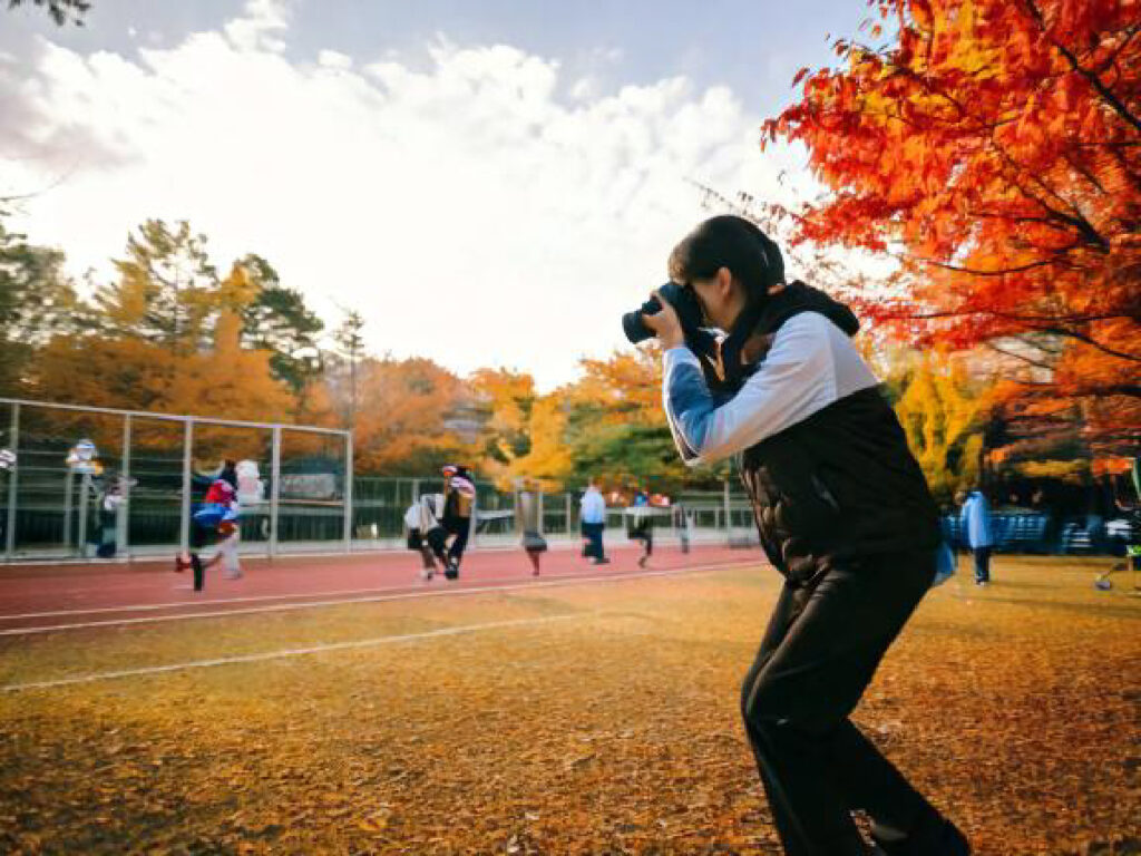 運動会を撮影する女性